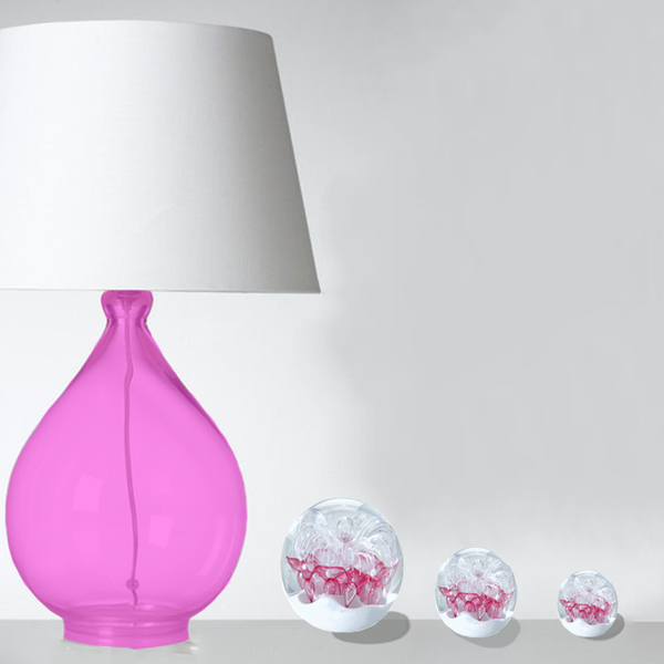 Mise en situation des sulfures presse papier modèle berlingot à coté d'une lampe en cristal rose.